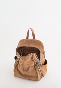 Tan suede rygsæk med dobbelte lynl�åse, rund form, forlommes og topgreb. Indersiden har et ekstra lynlåslommer.