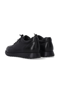 Černé kožené sneakers s kulatou špičkou, texturovanými panely a plochou gumovou podrážkou. Mají černé tkaničky a minimalizované designové akcenty.