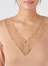 Top aderente color nudo con profondo scollo a V e dettagli in pizzo intricati sul collo. Tessuto morbido con maniche lunghe.