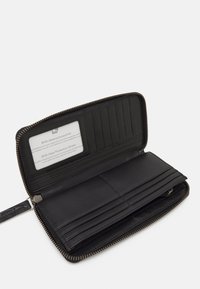 Portefeuille en cuir noir avec fermeture éclair, plusieurs emplacements pour cartes et une carte de protection RFID visible. Texture lisse et design élégant.