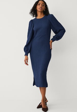 Vestito midi blu navy in tessuto strutturato con maniche a sbuffo e spacco laterale. Realizzato in un tessuto leggero e elasticizzato per comfort e libertà di movimento.