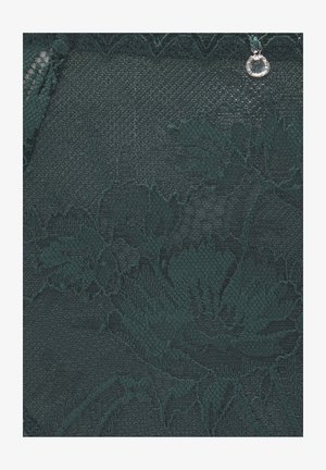 Tissu en dentelle vert foncé avec des motifs floraux, des textures complexes et un bord festonné, rehaussé d'un petit pendentif argenté.