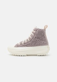 Höga sneakers med en fluffig lavendelfärgad ovandel, vit gummisula och texturerad tandad kant. Snörningsdesign och bakre dragtab.