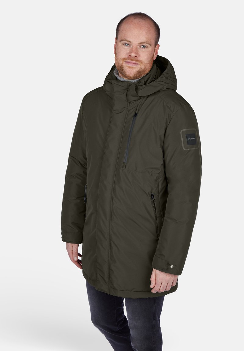 Mörkgrön isolerad parkas med huva, dragkedjefickor och en texturerad lagning på ärmen. Tyget verkar slätt och vattenavvisande.