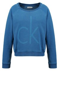 Modrá mikina s kulatým výstřihem, dlouhými raglánovými rukávy a velkým tónovaným logem "ck" na přední straně. Vyrobena z měkké, strukturované tkaniny.