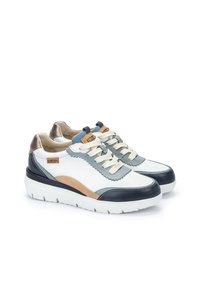 Zapatillas de cuero blancas con acentos en azul marino y azul claro. Presenta un diseño texturizado, cierre de cordones en la parte frontal y una suela gruesa blanca.