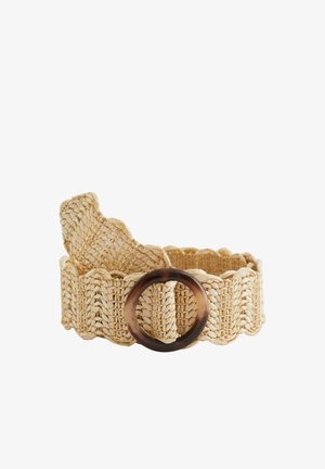 Cintura intrecciata in paglia beige con bordi smerlati e grande fibbia tonda in tartaruga, arrotolata su sfondo bianco.