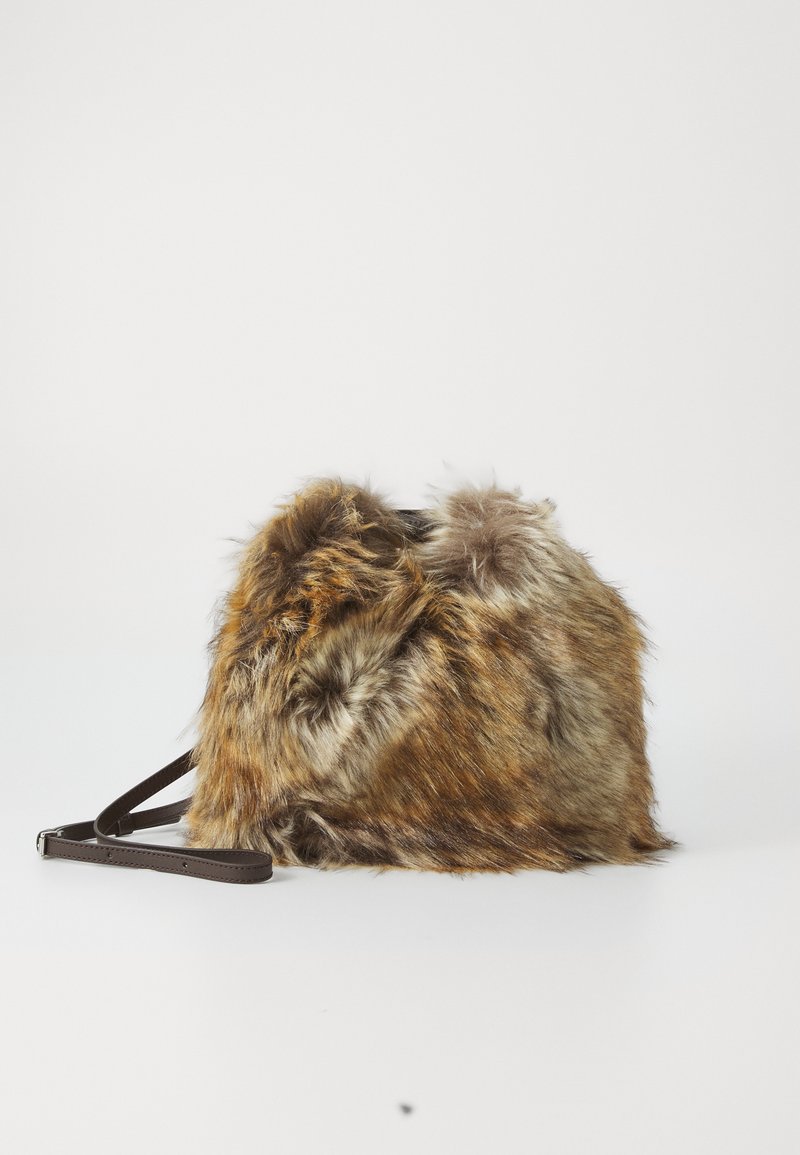 Brūns mākslīgās kažokādas soma ar mīkstu, teksturētu virsmu, kas ir aprīkota ar brūnu ādas plecu siksnu un noapaļotu formu. Kompakts dizains ar pūkainiem akcentiem.