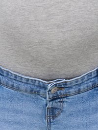 Nærbilde av oppknappet blå denim jeans med grå skjorte stukket inn over.