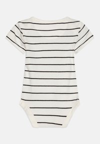 Kortermet bodysuit i myk hvit bomull med svarte horisontale striper, rund halsutringning og trykknapper nederst for enkel påkledning.