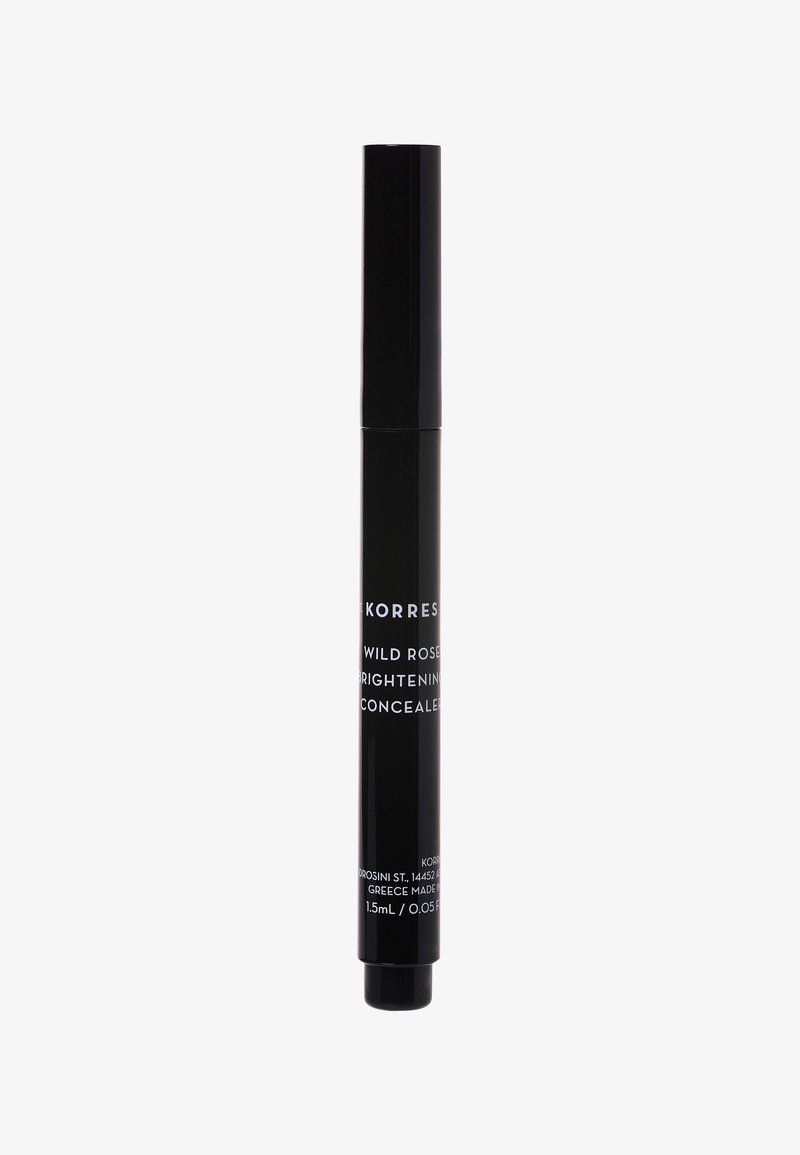 Czarna cylindryczna tubka korektora z aplikatorem obrotowym. Białe napisy: "Korres Wild Rose Brightening Concealer." Pojemność: 1,5 mL.
