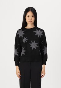 Black knit sweater featuring silver star patterns, round neck, and ribbed hem. Long sleeves with a relaxed fit. Textured fabric.