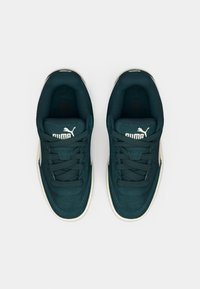Dark green suede sneakers featuring a white rubber sole, rounded toe, and flat laces with embossed logo on the tongue.