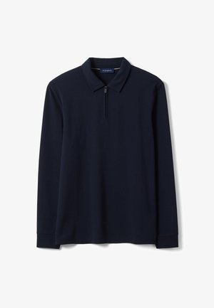 Polo blu navy a manica lunga con zip sul colletto e una piccola etichetta del marchio all'interno del colletto.