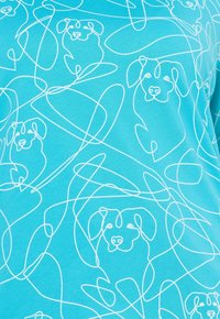Camiseta de color azul claro con dibujos de perros en líneas blancas entrelazados con bucles abstractos. Tejido suave con una textura lisa, diseño casual.