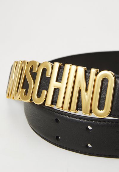 Must have nahkavöö, millel on silmapaistv kullatooniga "MOSCHINO" logo pandla. Sile tekstuur, regulatsiooniaugud ja ümarad servad.