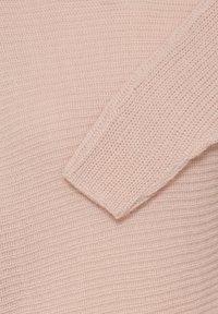 Pull tricoté rose clair avec un motif texturé et des manches longues. Le tissu est doux et respirant, offrant une coupe décontractée.