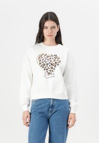 Weißer Sweatshirt mit einem großen Herzmotiv, das aus unterschiedlich gefärbten Herzen besteht, und dem Text "Liebe versagt nie" darunter. Bequemer Schnitt.