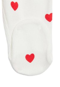 Weißer Socken mit gerippter Struktur, die mit kleinen roten Herzmustern verziert sind. Das Design ist einfach und bedeckt den oberen Teil der Socken.