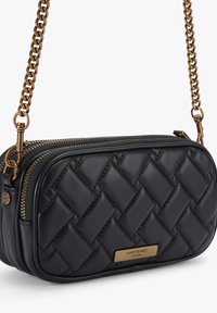 Czarna pikowana skórzana torebka na ramię z złotym łańcuchem, zapięcie na zamek błyskawiczny i metalowy akcent z logo z przodu. Gładka faktura.