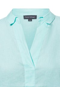 Lichtblauwe linnen blouse met een notch-kraag en een v-hals. Heeft een label met het merk "Franco Callegari" en maat 36.
