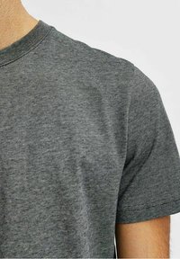 Grårandig t-shirt med rund halsringning, korta ärmar och en slät yta, med subtila horisontella mönster genom tyget.