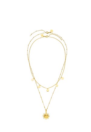 Doppellagige goldene Kette mit fünf kleinen runden Scheiben an der kürzeren Kette und einem sonnenförmigen Anhänger an der längeren Kette.