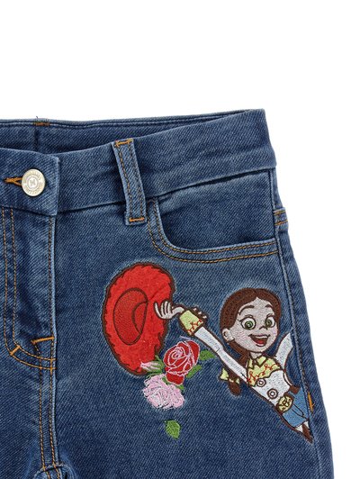 Τζιν από denim με έγχρωμο κεντημένο καρτούν κορίτσι που κρατάει ένα κόκκινο καπέλο και ροζ και κόκκινα τριαντάφυλλα κοντά στην μπροστινή τσέπη.