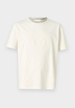 Tricou crem cu mânecă scurtă, cu guler rotund striat și design cu logo embossat pe partea din față, fabricat din material din bumbac.