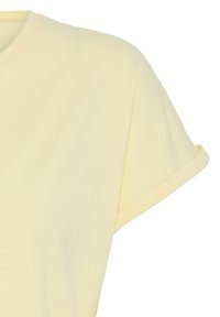 T-shirt jaune pâle à manches courtes avec un col rond et un détail de manches retroussées.