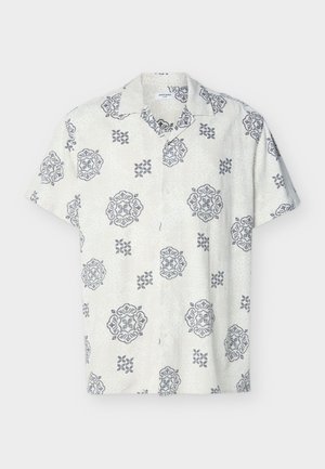 Camisa blanca de manga corta con botones y patrones florales y geométricos grises distribuidos de manera uniforme sobre la tela.