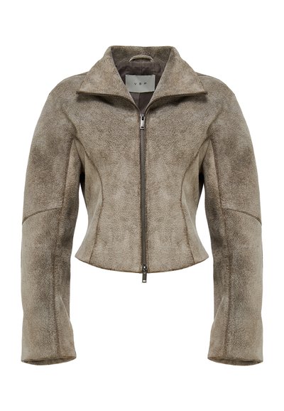 Kraća smeđa jakna od antilopa sa stojeći ovratnikom i prednjim patentnim zatvaračem. Ima široke rukave i glatku teksturu sa suptilnim toniranim varijacijama.