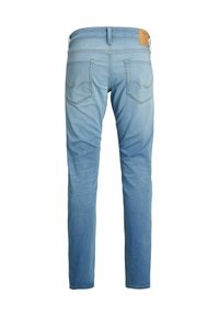Feked sinised denim püksid sirge lõikega, millel on kaks tagataskut ja nahkpatch vööl. Kangas on pleekinud.