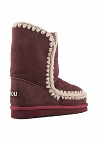 Stivaletto alla caviglia in camoscio bordeaux con cucitura crema lungo il bordo, suola piatta in gomma e patch con logo sul lato. Texture liscia e design semplice.