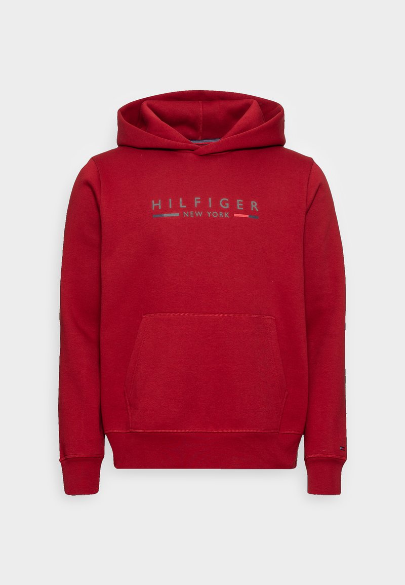 Raudona džinsinė striukė, pagaminta iš minkštos medžiagos, su priekinėmis kišenėmis, su stringais reguliuojamu kapišonu ir „HILFIGER NEW YORK“ logotipu, atspausdintu mėlynoje ir baltoje spalvose.