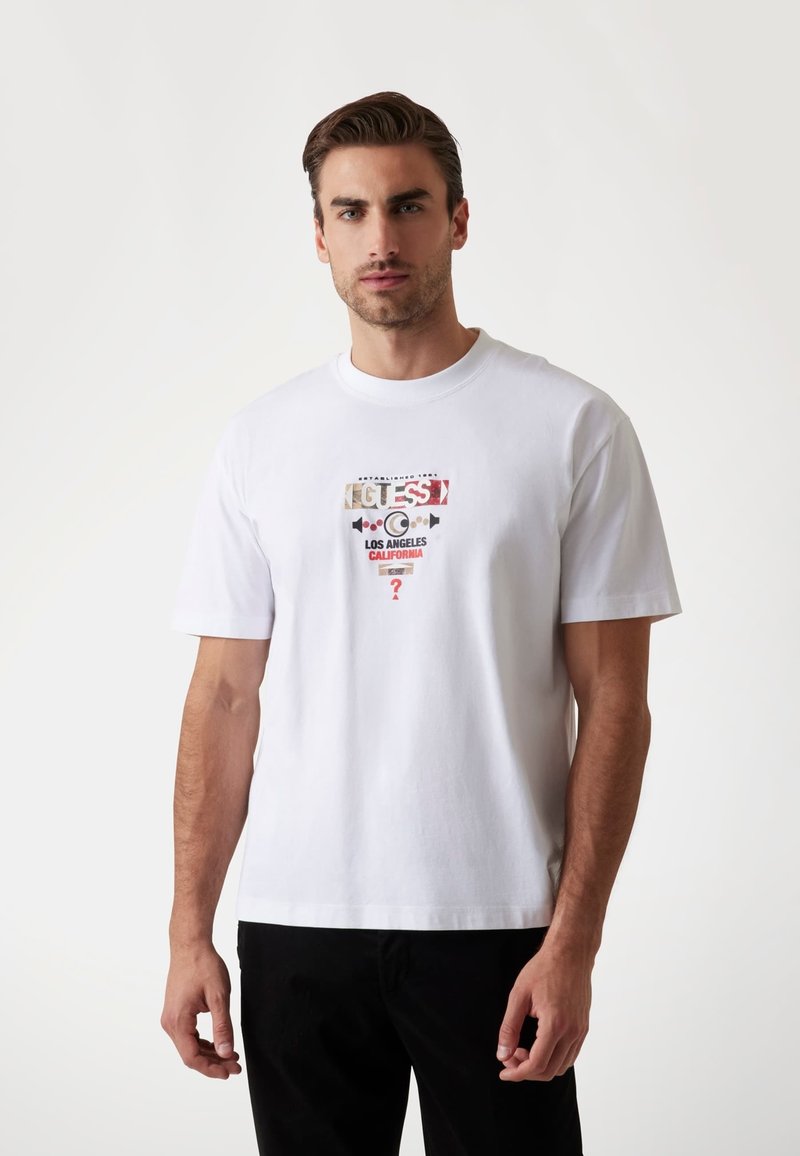 Weißes Baumwoll-T-Shirt mit einem Grafikdruck, auf dem "GUESS", "LOS ANGELES" und "CALIFORNIA" steht. Mit kurzen Ärmeln und einem klassischen Rundhalsausschnitt.