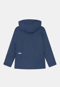 Marineblaue Kapuzenjacke mit langen Ärmeln, sichtbaren Nähten und einem kleinen weißen Markenetikett an der unteren linken Rückseite.