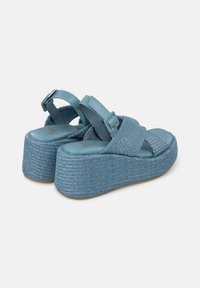Lichtblauwe platform sandals met geweven textuur, kruisbanden en verstelbare gesp. Dikke, getextureerde zool met een gladde binnenzool.