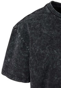 Black cotton t-shirt with a faded texture, round neckline, and short sleeves. Features a slightly distressed finish and casual cut.