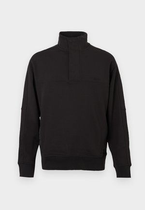 Sweatshirt preto de pulôver feito de um suave misto de algodão, apresentando um colarinho alto com fecho de botão, punhos canelados e um ajuste relaxado.