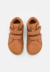 Bruine leren schoenen met een gestructureerde afwerking, hoge ontwerp en twee verstelbare klittenbandbanden. Platte rubberen zool. Zichtbare stikseldetails.