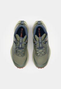 Baskets de sport vertes avec une tige en maille texturée, des accents bleus et une marque orange. Elles sont dotées d'une semelle rembourr�ée et d'un col rembourré.