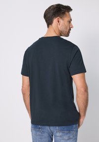 Tmavě námořnické tričko s kulatým výstřihem z bavlny, s krátkými rukávy a rovně střiženým lemem, s hladkou texturou a minimálním designem.