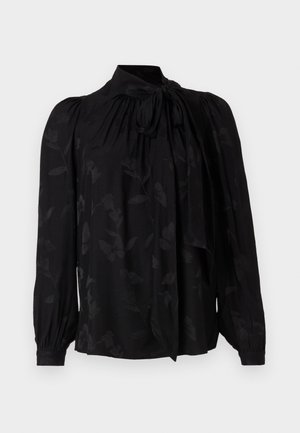 Svart bluse med høy krage og knytedetalj. Har et subtilt blomstermønster og puffer lange ermer med samlede mansjetter. Glatt tekstur.