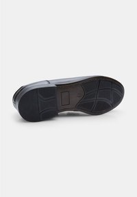 Suela de zapato de cuero negro con un patrón de agarre de goma texturizada, que presenta una punta redondeada y un pequeño detalle de corte rectangular.