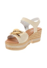 Sandali con zeppa in materiale sintetico crema, con un accento di catena dorata. Piattaforma avvolta in juta e cinturino alla caviglia regolabile per maggiore supporto.