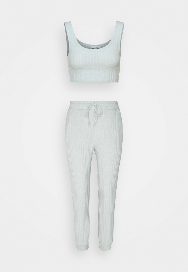 Crop top sans manches en maille côtelée gris clair et ensemble de pantalons de jogging taille haute à cordon assortis.