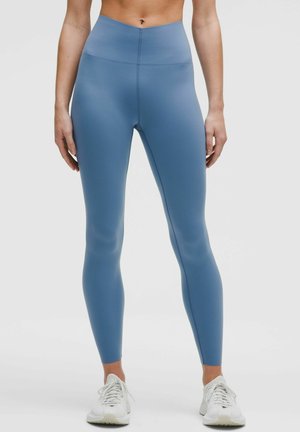 High-waisted blue leggings made of a smooth, stretchy material, featuring a seamless design and a fitted silhouette.