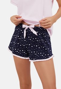 Granatowe szorty w gwiazdki z białą falbanką i jasnoróżowym satynowym ściągaczem. Miękka tkanina, elastyczny pas dla komfortu.