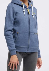 Blå zip-up huvtröja i bomullsmix med dragsko i huvudet, två framfickor och kontrasterande gula detaljer och dragkedja.